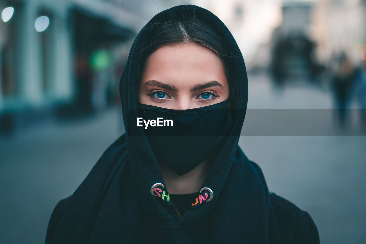 PORTRAIT OF BEAUTIFUL WOMAN STANDING IN CITY