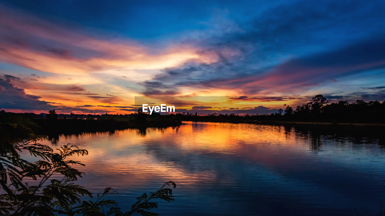 Scenic view of lake against orange sky