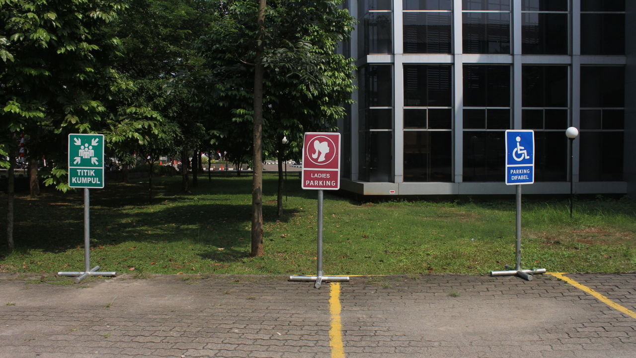 ROAD SIGN AGAINST TREE