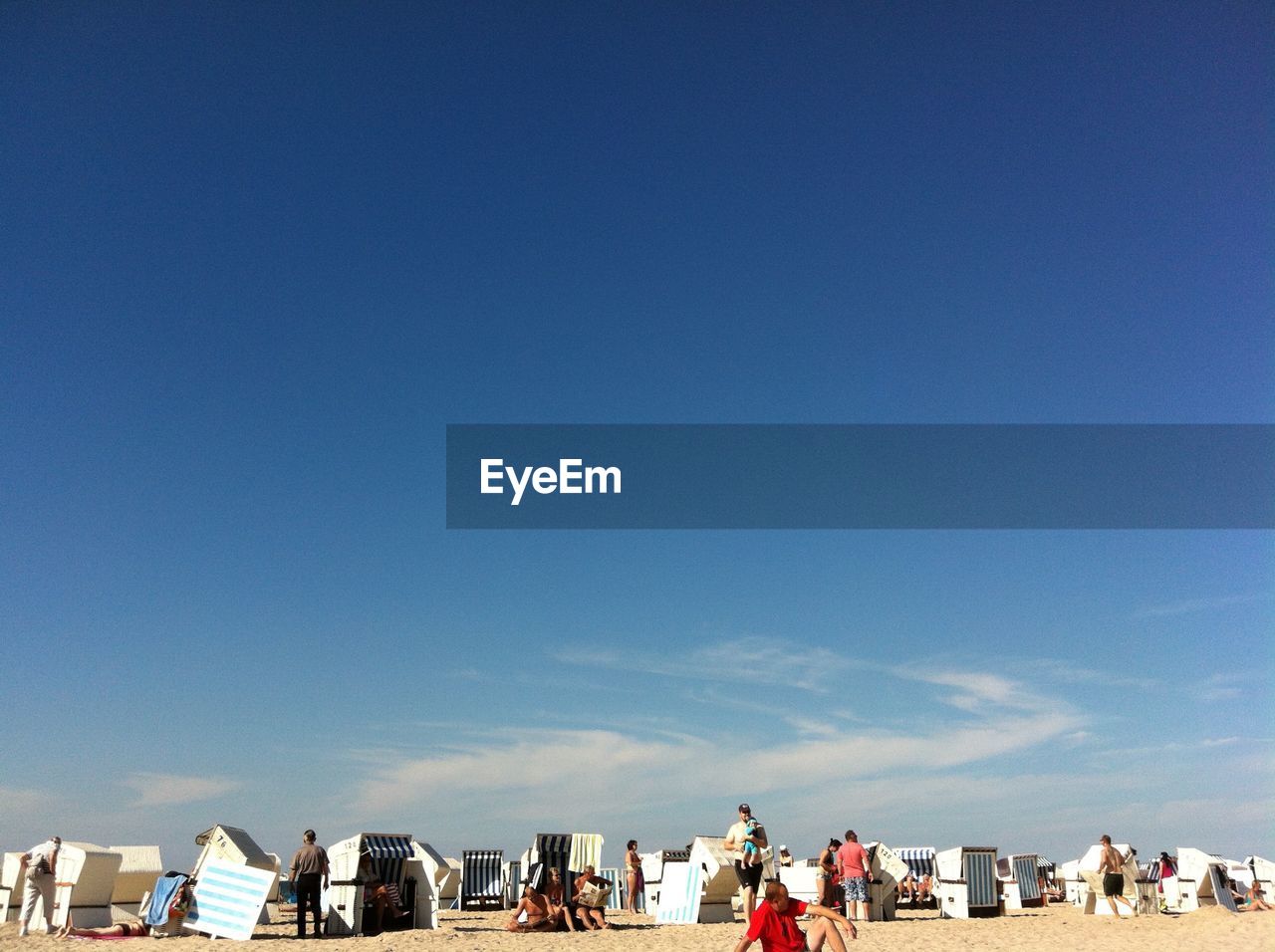 People at beach against blue sky