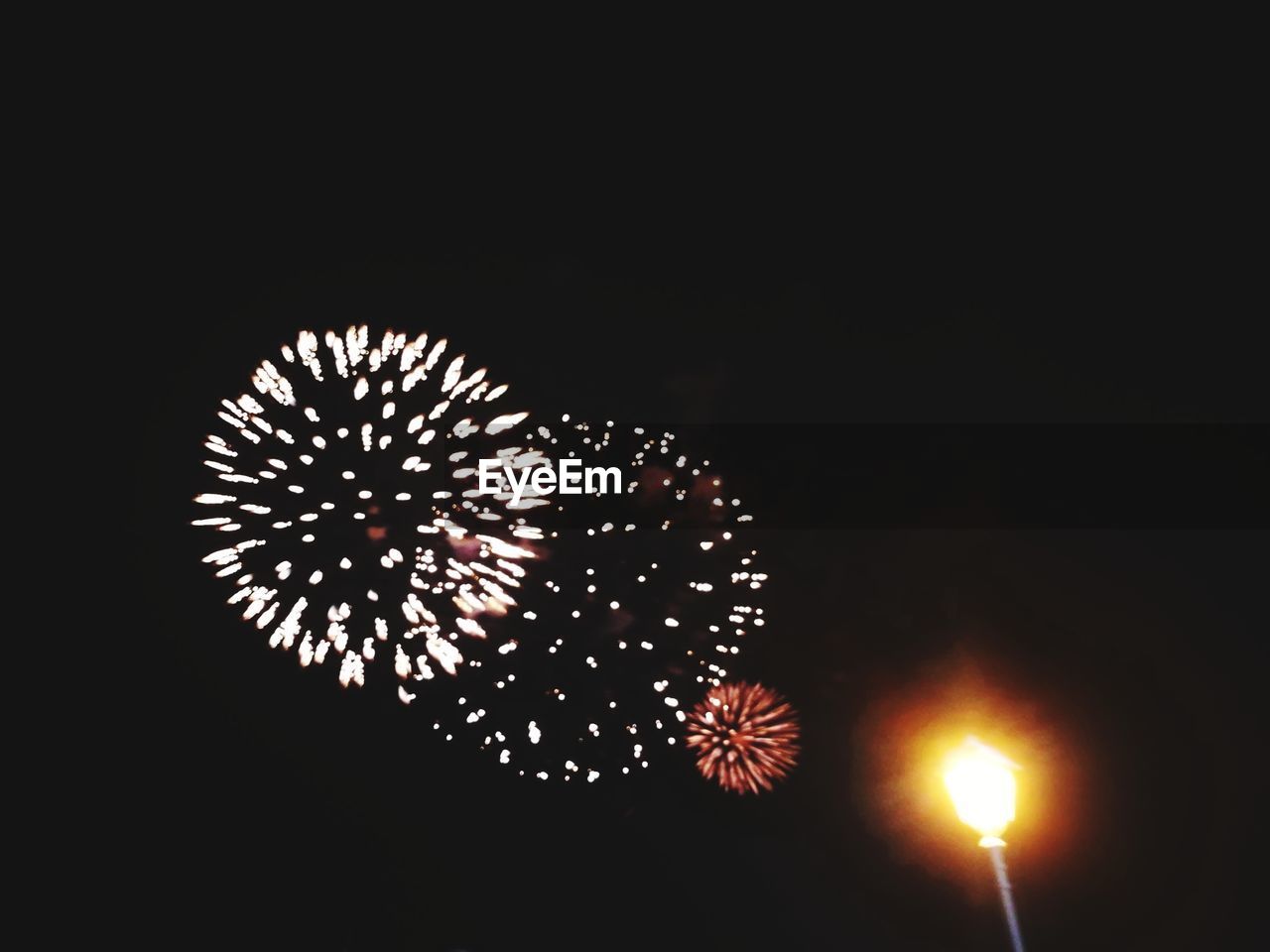 LOW ANGLE VIEW OF FIREWORKS EXPLODING IN NIGHT SKY