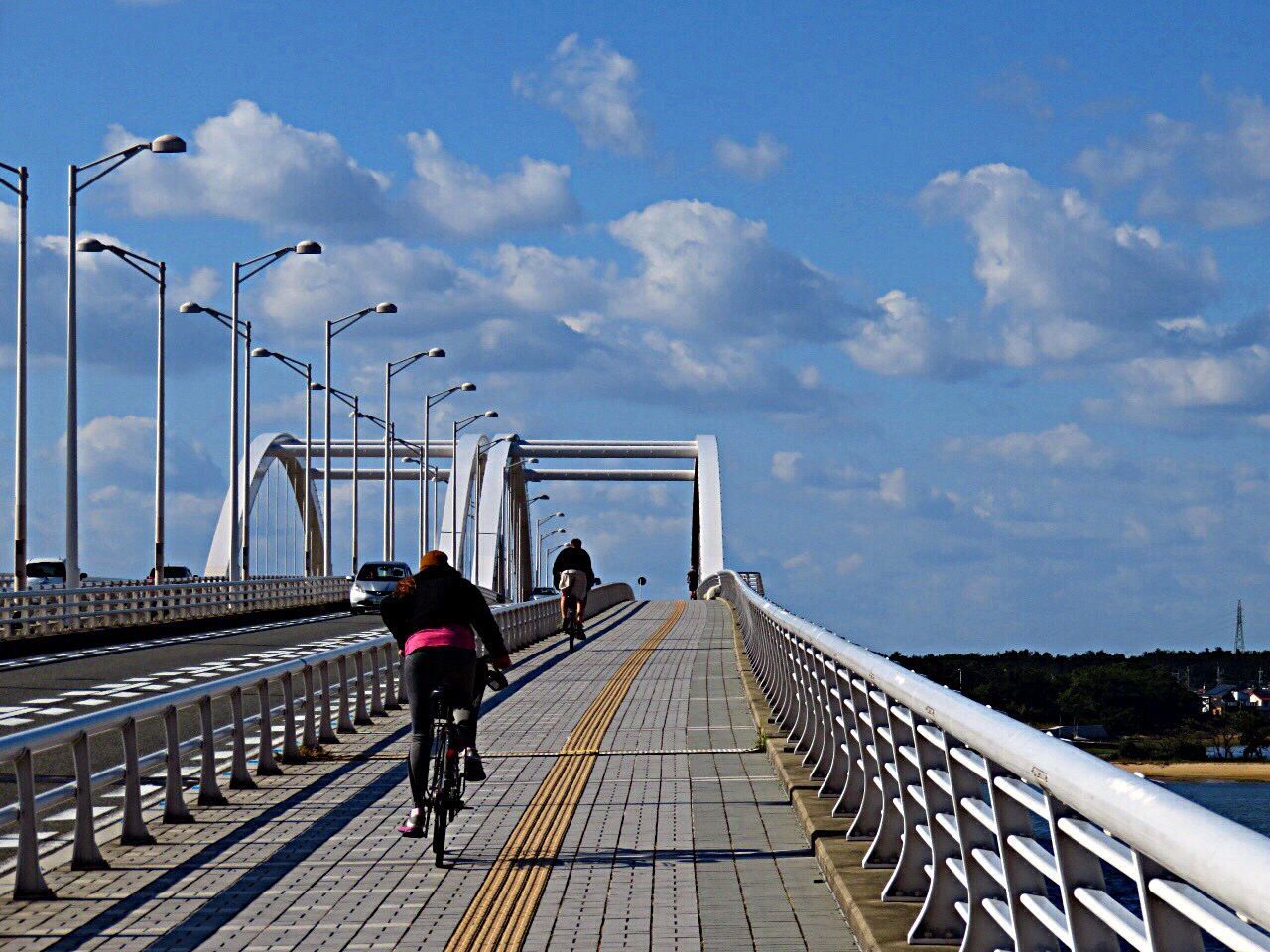 REAR VIEW OF WOMAN STANDING ON RAILING