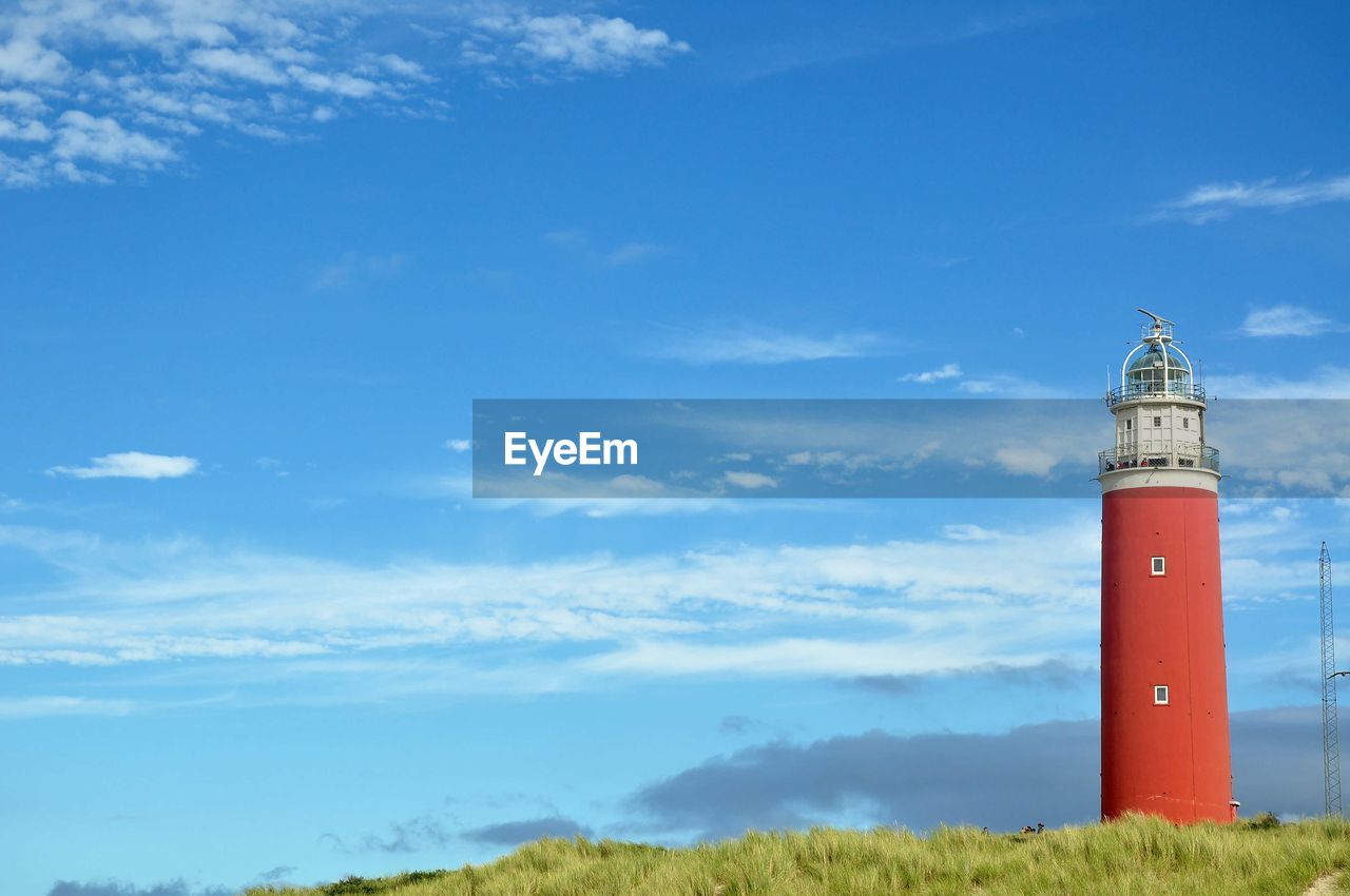 LIGHTHOUSE AGAINST BLUE SKY AND CLOUDS