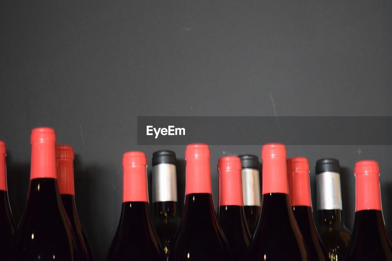 Close-up of wine bottles against gray background