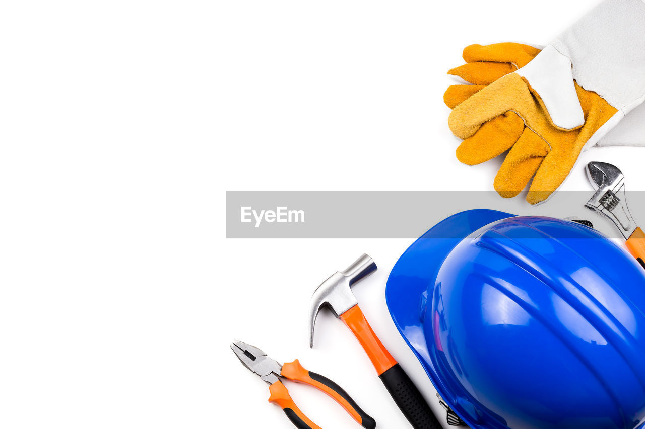 High angle view of hardhat with work tools on white background