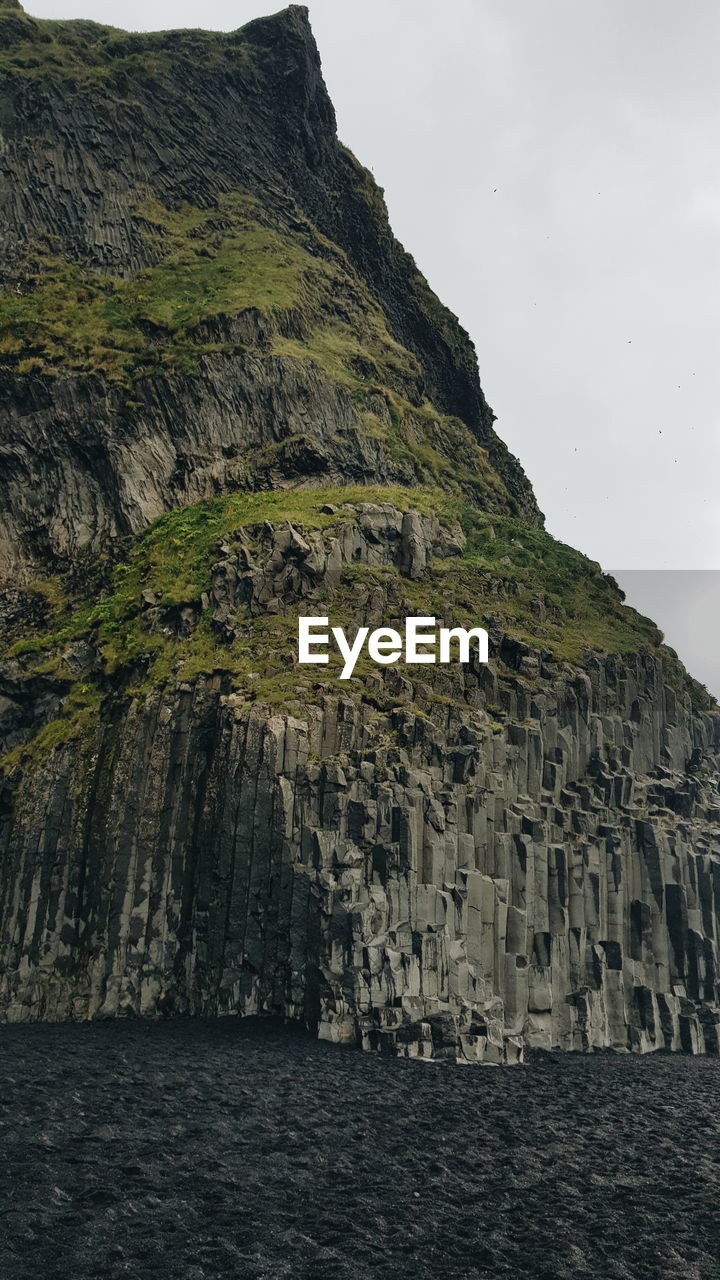 Scenic view of rock formation by sea against sky