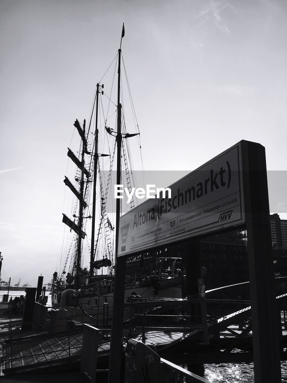 LOW ANGLE VIEW OF CRANES AT COMMERCIAL DOCK AGAINST SKY