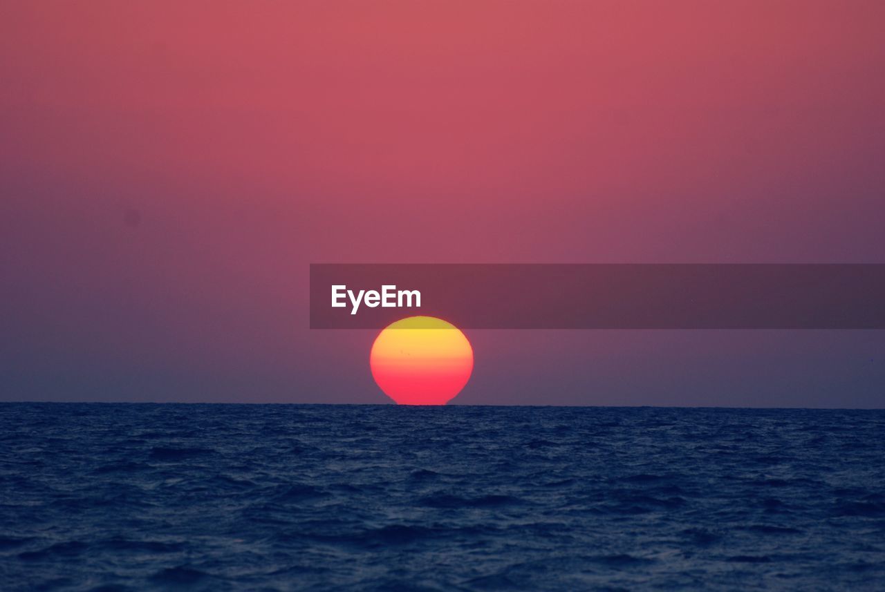 Scenic view of sea against romantic sky at sunset