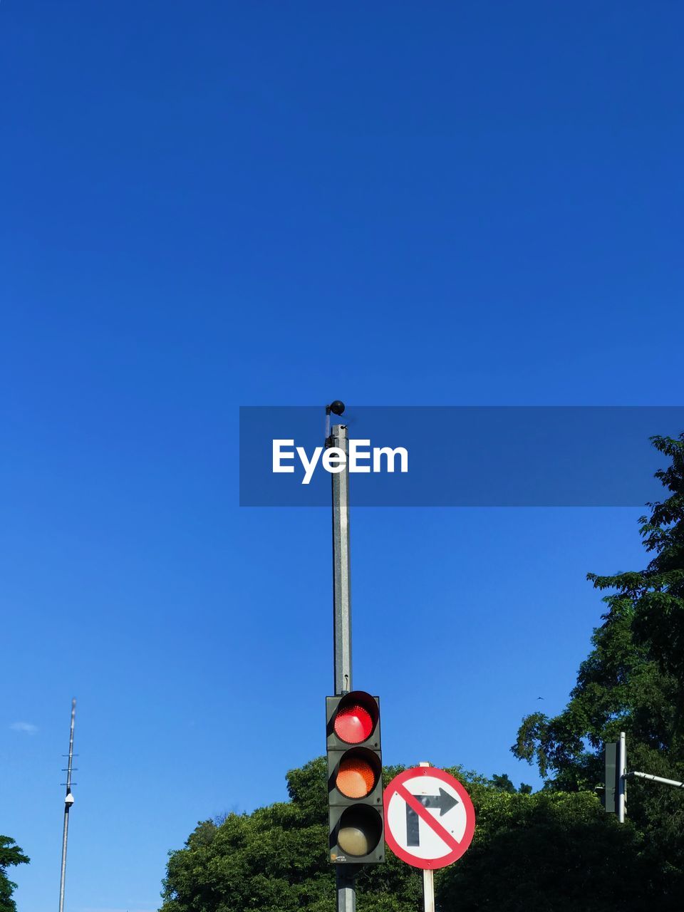 LOW ANGLE VIEW OF ROAD SIGNS AGAINST BLUE SKY