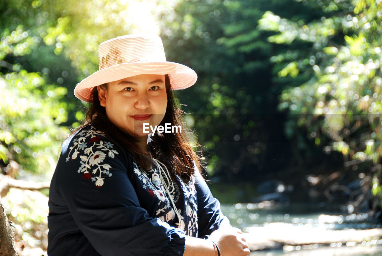 Portrait of beautiful woman wearing hat sitting outdoors