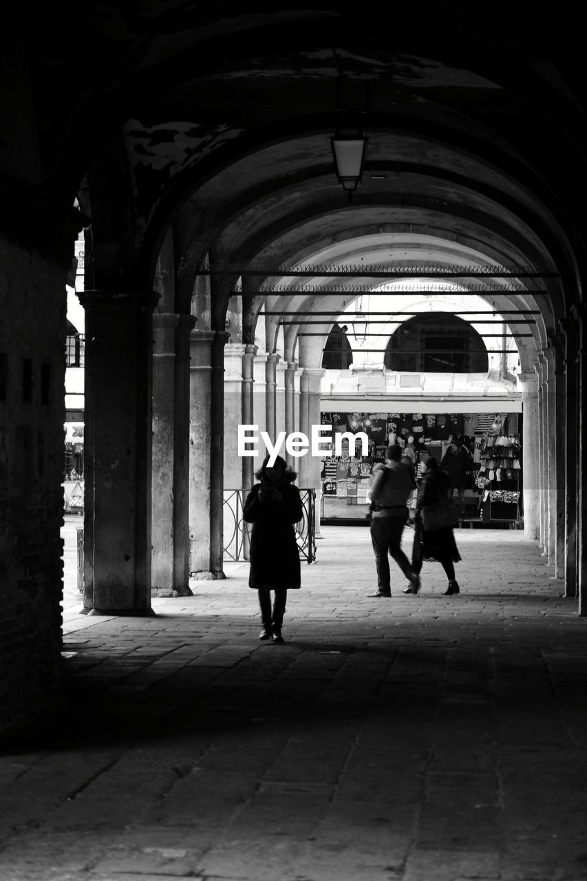 REAR VIEW OF SILHOUETTE PEOPLE WALKING IN BUILDING