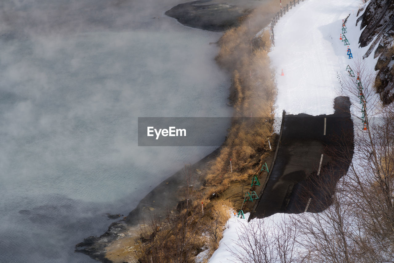 High angle view of snow covered mountain road by sea