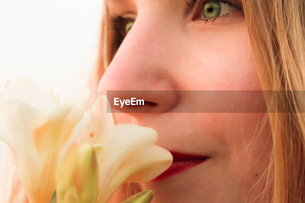 Close-up of woman smelling flowers