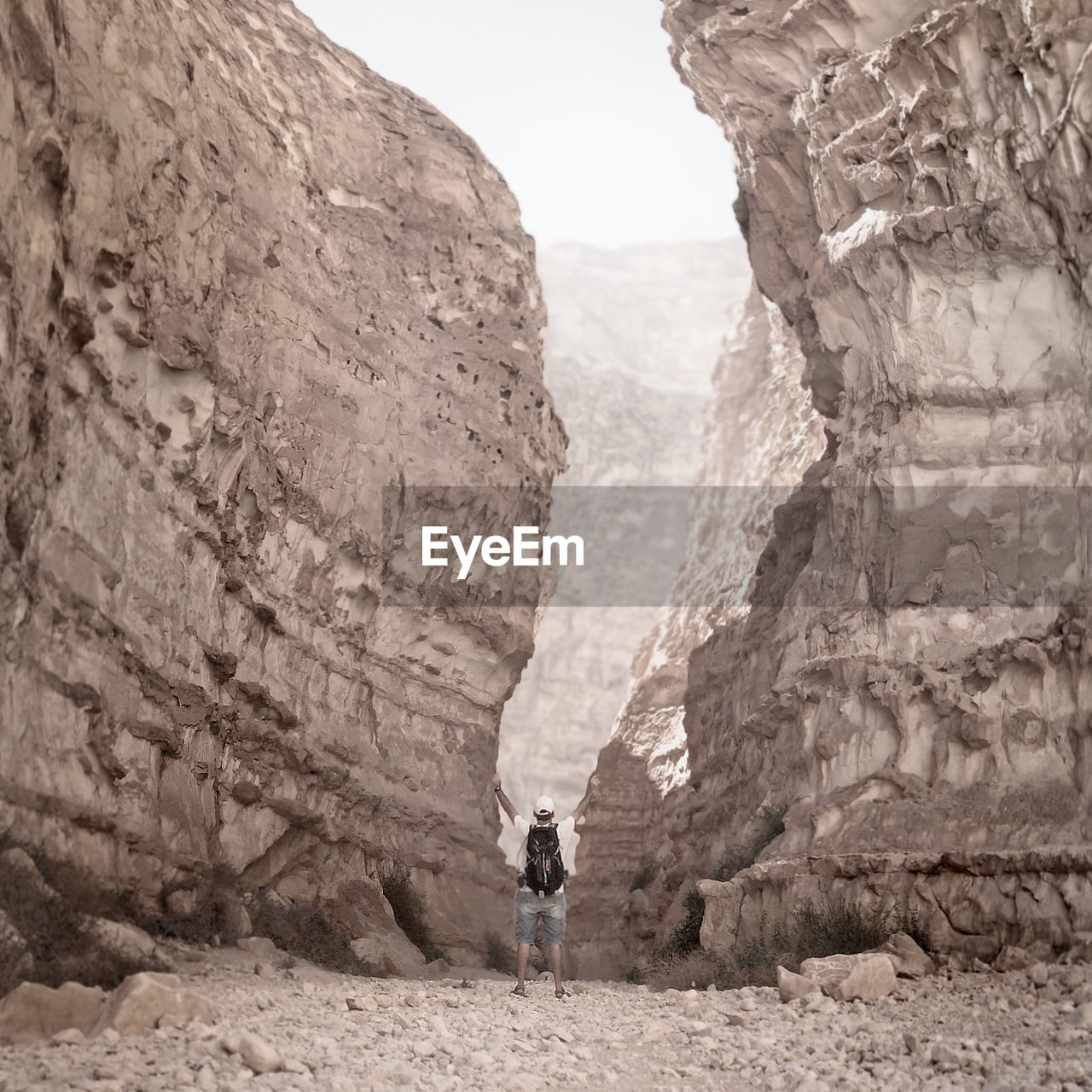 Rear view of man hiking on rocky mountain