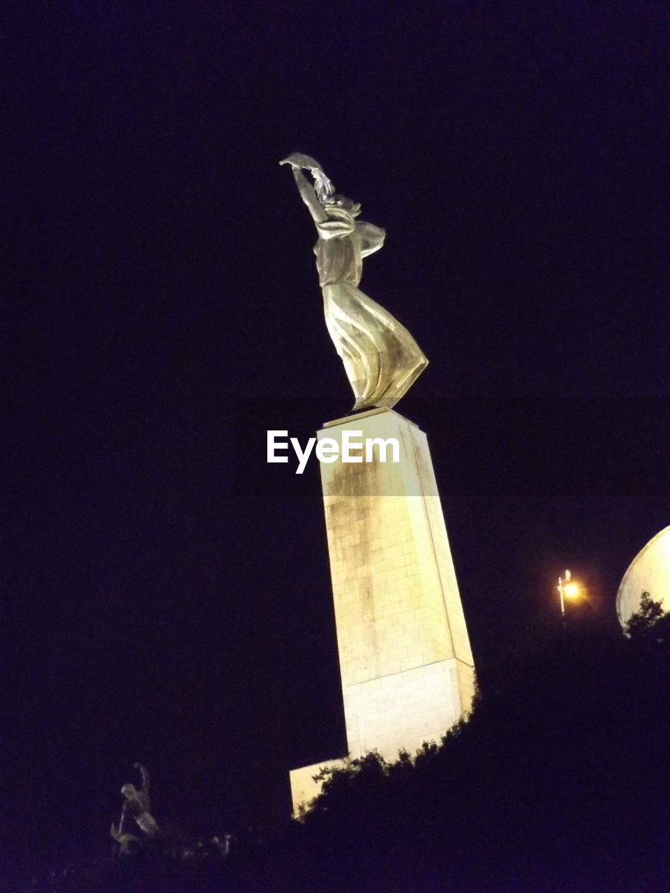 Low angle view of statue against dark sky