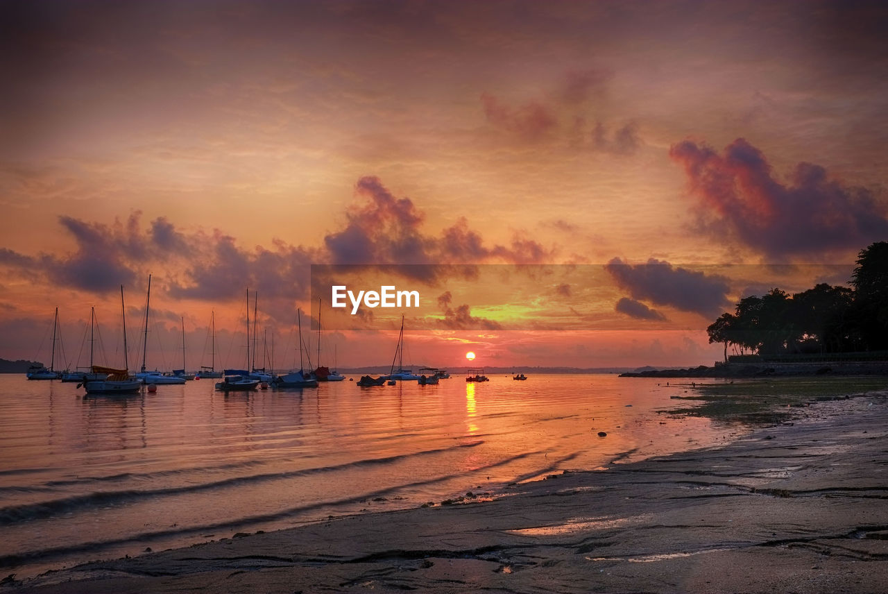 View of boats in sea at sunset