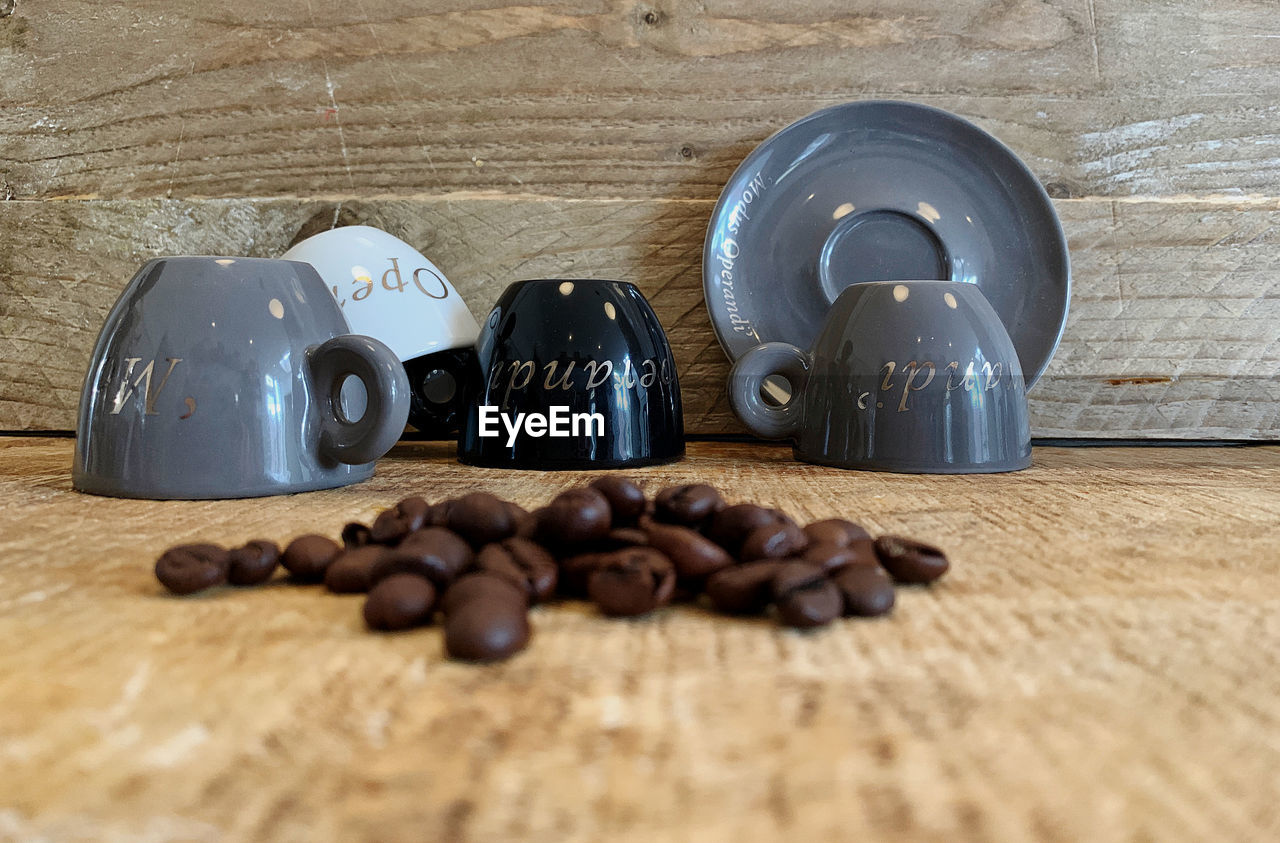 Close-up of coffee beans and cups on table