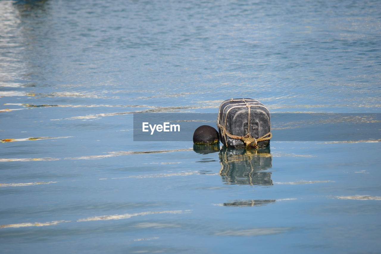 CLOSE-UP OF METAL CONTAINER ON SEA