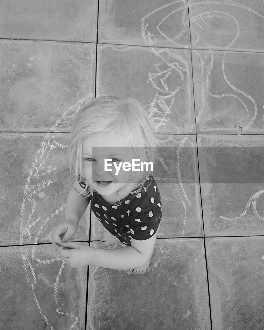 Portrait of girl standing by chalk drawing on floor