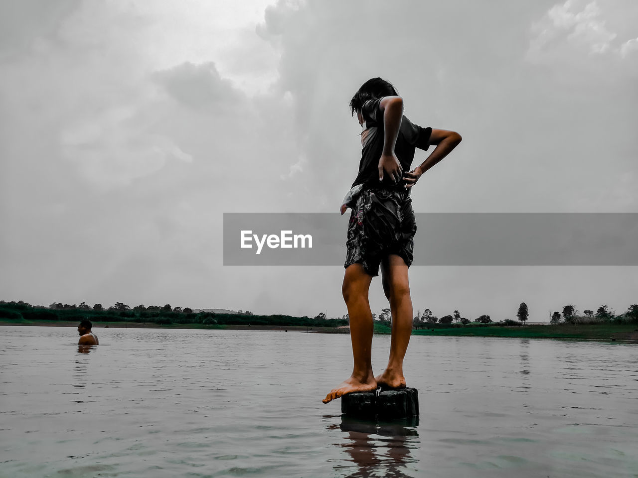 Rear view of woman standing in water against sky