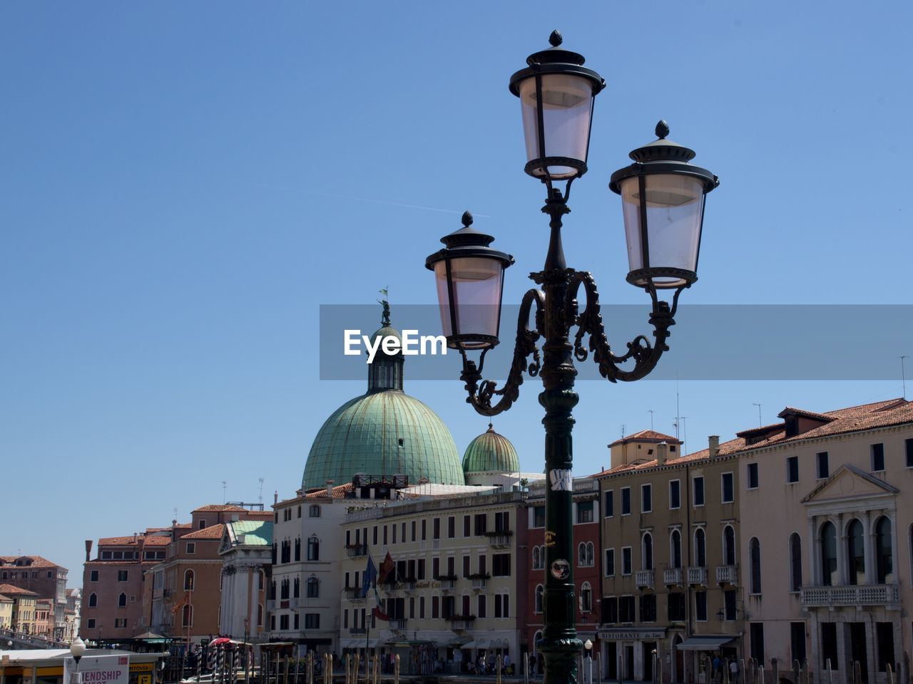 Low angle view of church and street light against clear blue sky