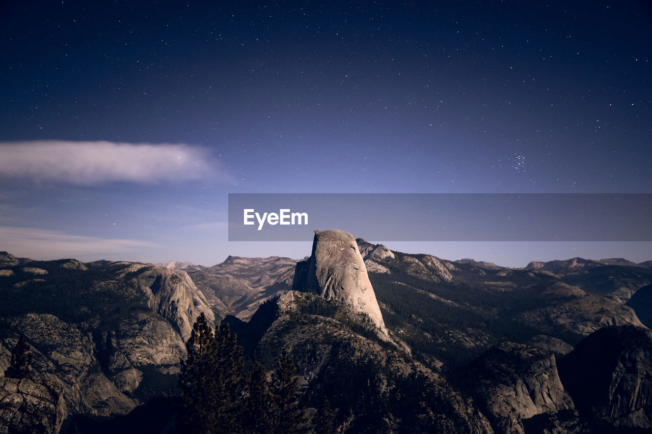 Scenic view of mountains against sky at night