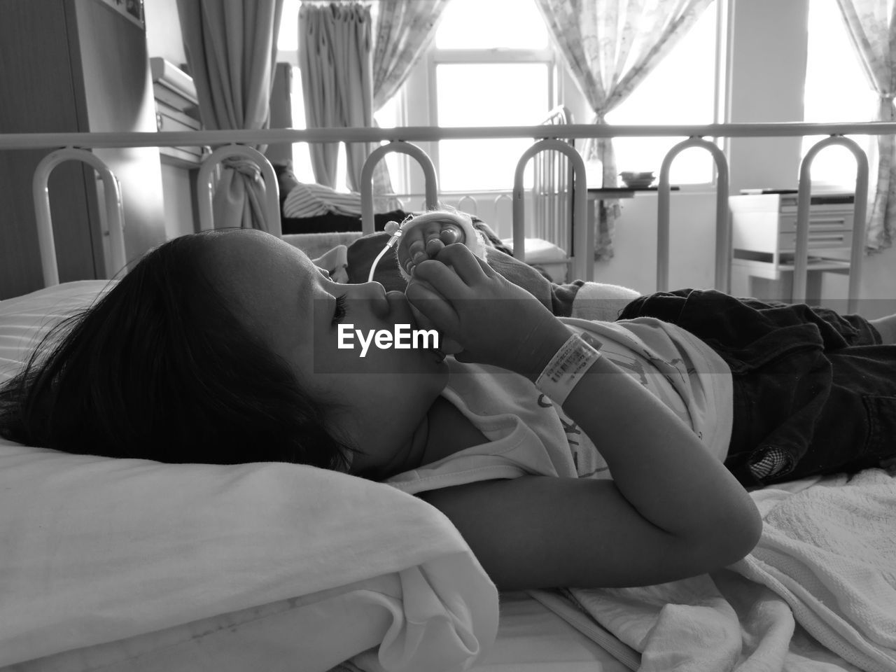 Close-up of girl eating fruit while lying on bed in hospital