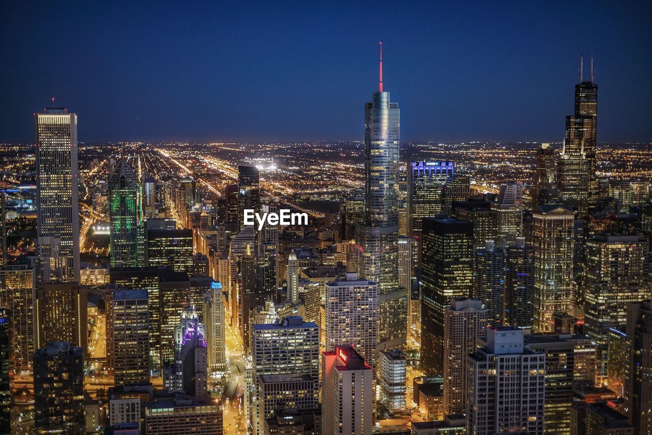 Aerial view of illuminated city buildings at night