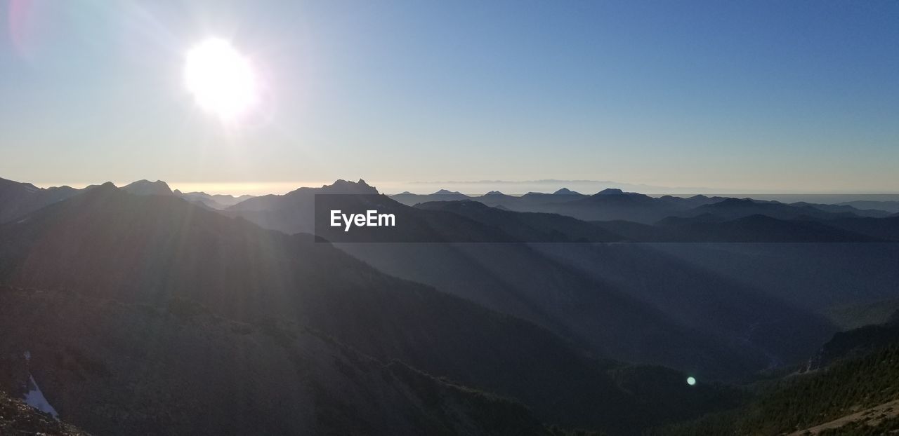 SCENIC VIEW OF MOUNTAINS AGAINST BRIGHT SKY