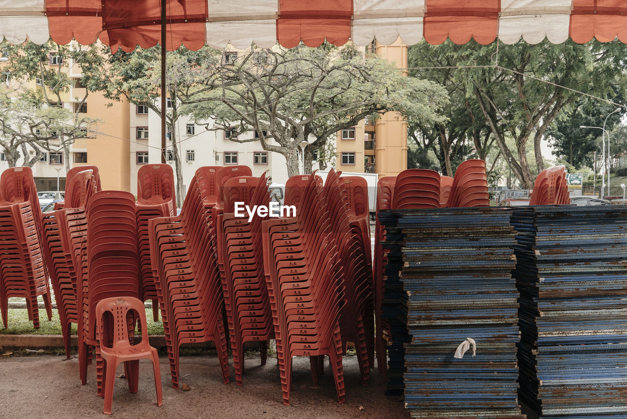 Stacked chairs and tables under tent