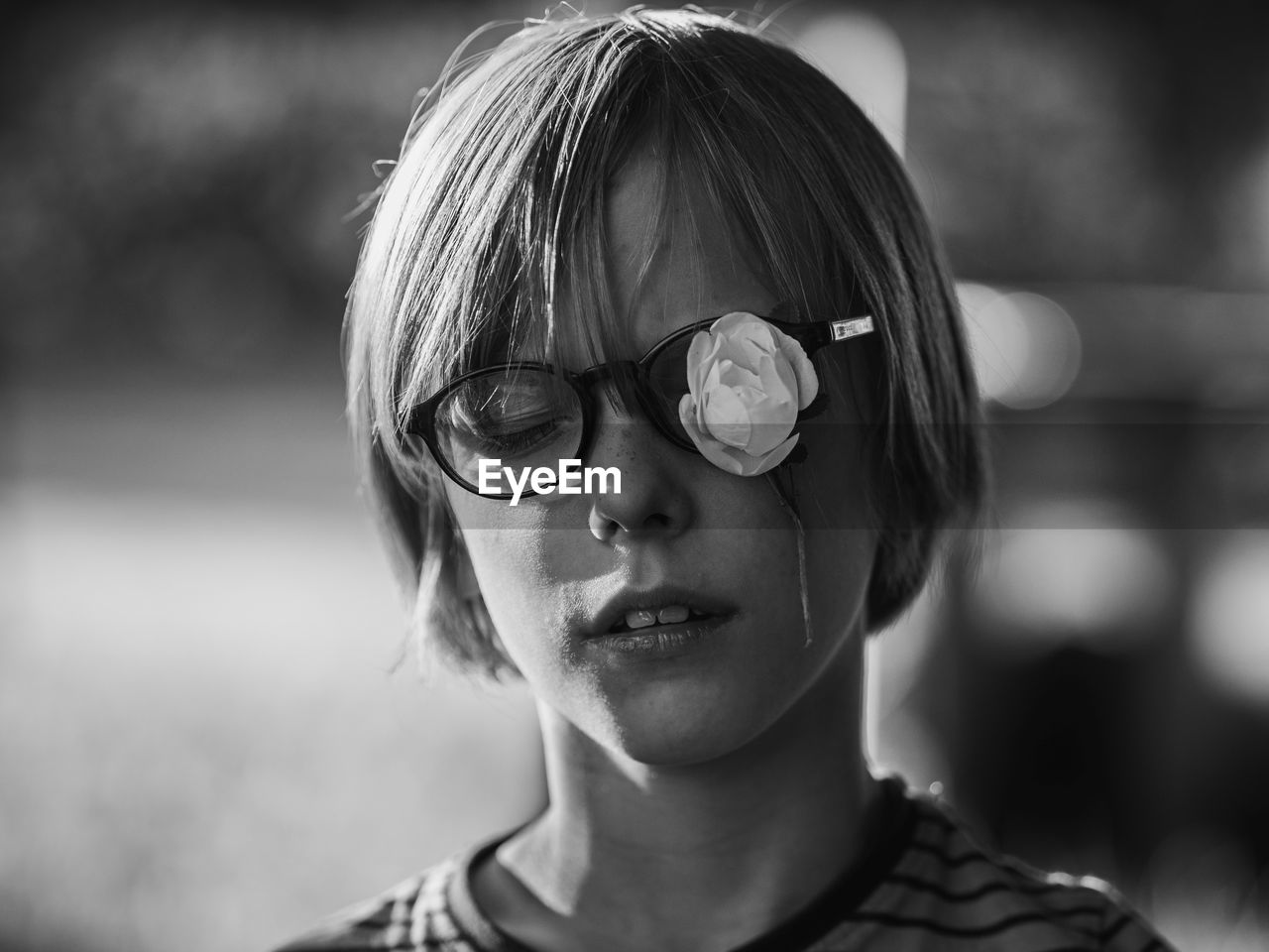 Close-up of cute boy wearing eyeglasses with artificial flower