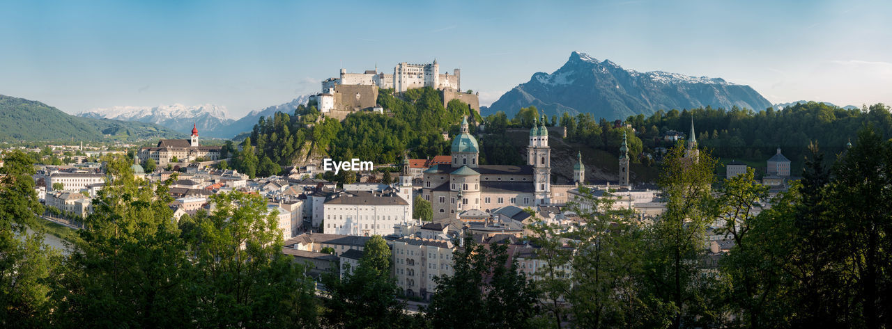 Panoramic view of the old town of Salzburg illuminated in beautiful afternoon light on a beautiful sunny day with blue sky in summer, Salzburger Land, Austria Alps Architecture Austria Austrian Baroque Blue Castle Cathedral Church City Cityscape Clouds Destination Europe Evening Festival Festspiele Festung Fortress Historic Hohensalzburg Landmark Landscape Light Medieval Mountains Mozart Nature Old Outdoors Panorama Panoramic Salzach Salzburg Salzburger Salzburger Festspiele Salzburger Land SalzburgerLand Sky Sound Of Music Building Exterior Built Structure Mountain Building Tree Plant Residential District Mountain Range Town No People Day History Travel Destinations TOWNSCAPE
