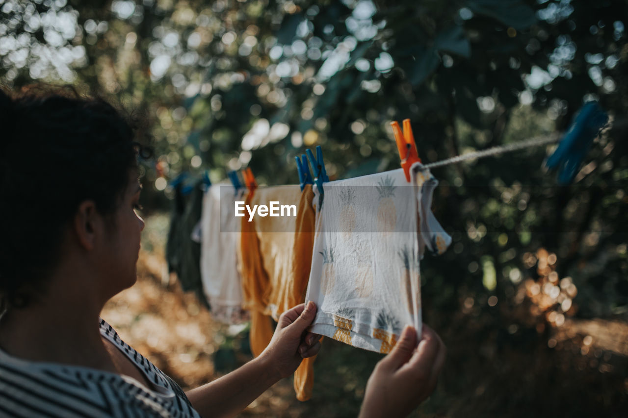 Woman drying laundry on clothesline