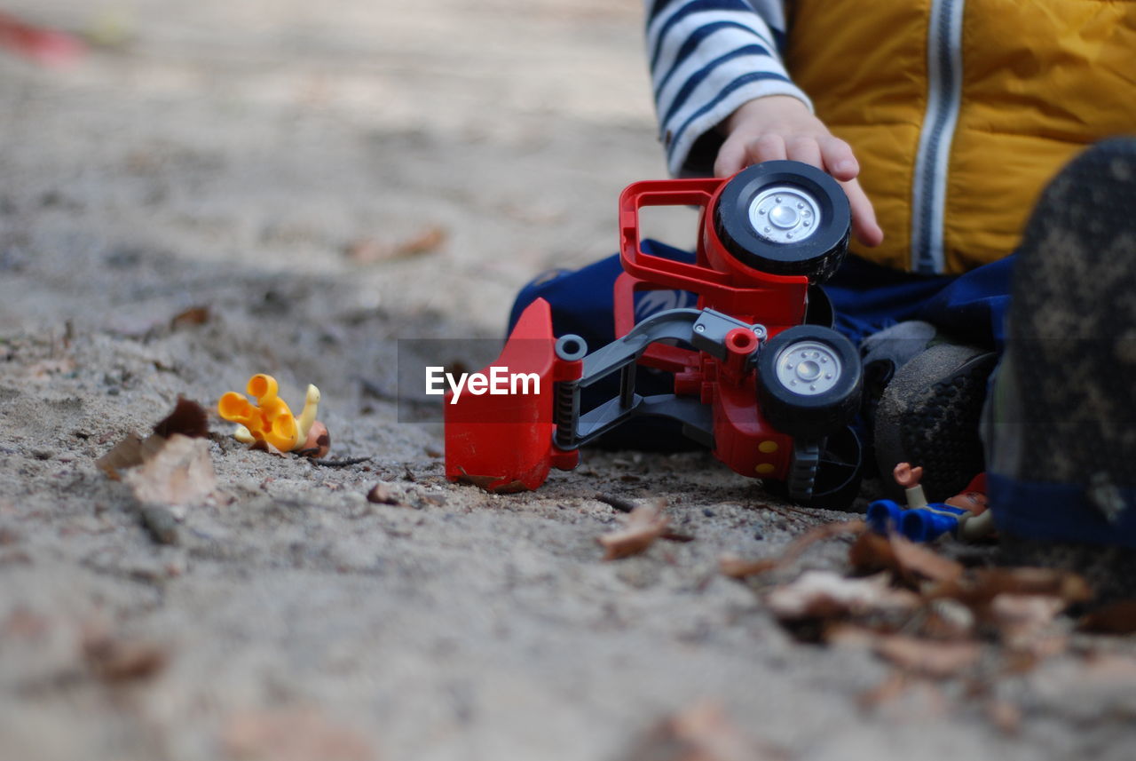 LOW SECTION OF MAN HOLDING TOY CAR