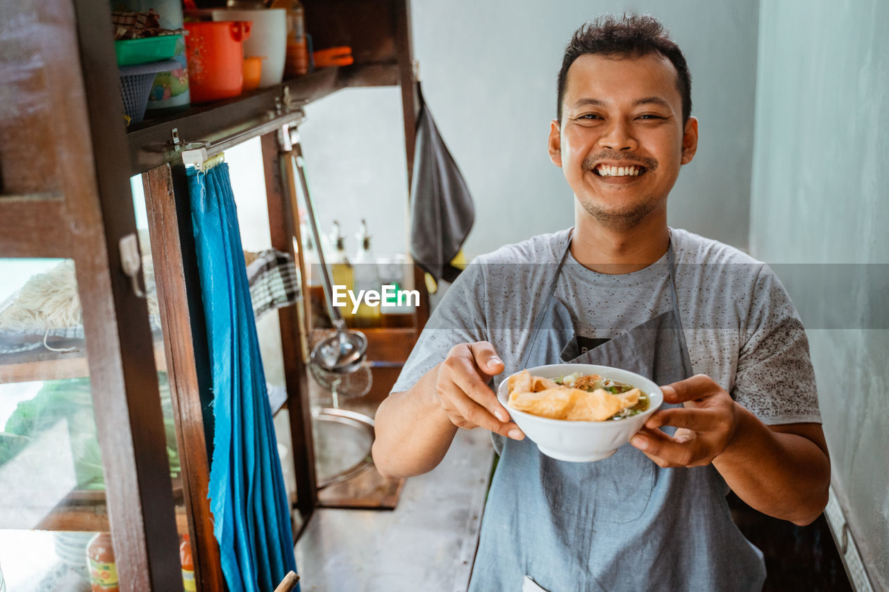 portrait of young man having food at home