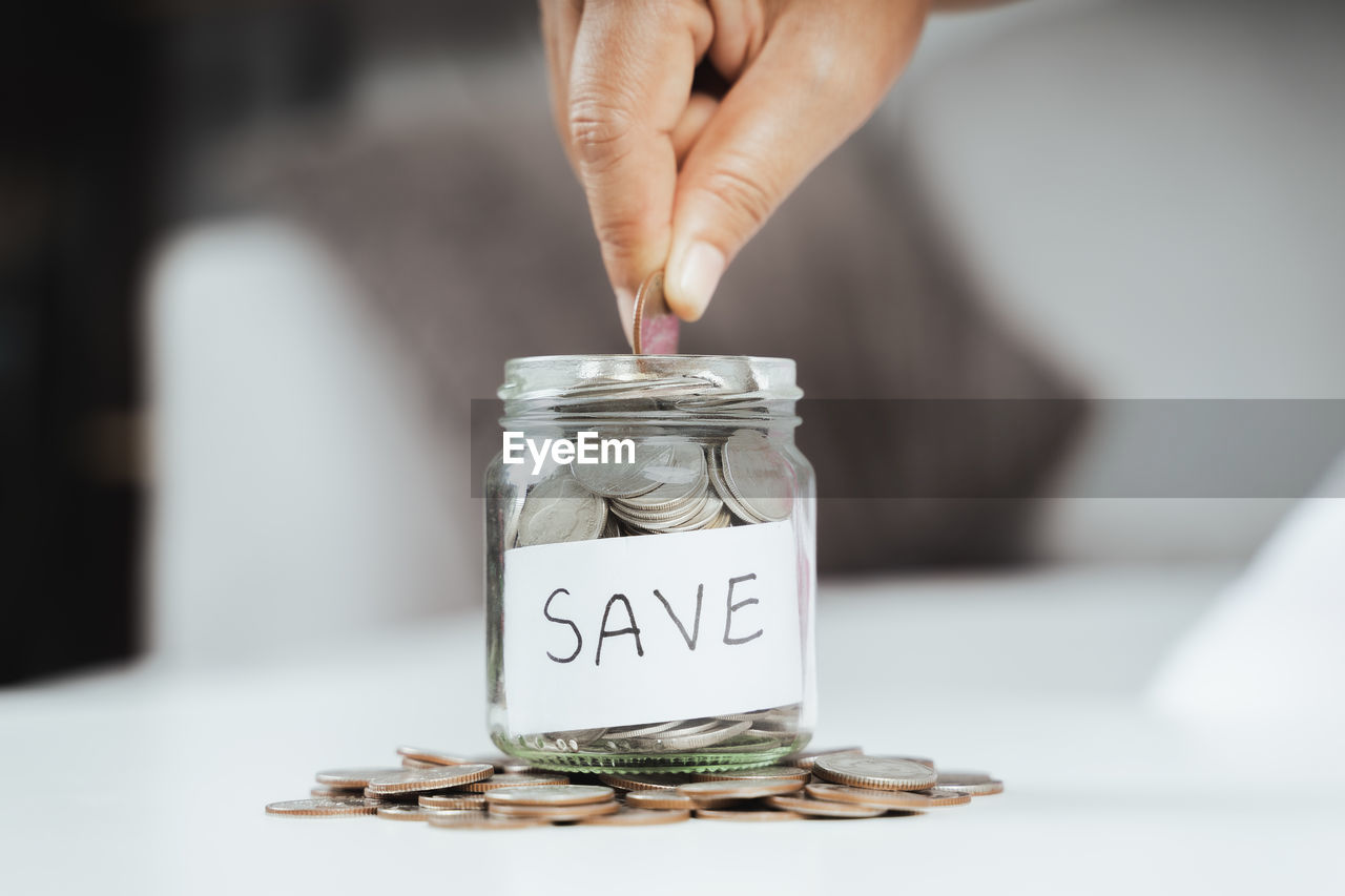 MIDSECTION OF PERSON HOLDING GLASS JAR WITH TEXT