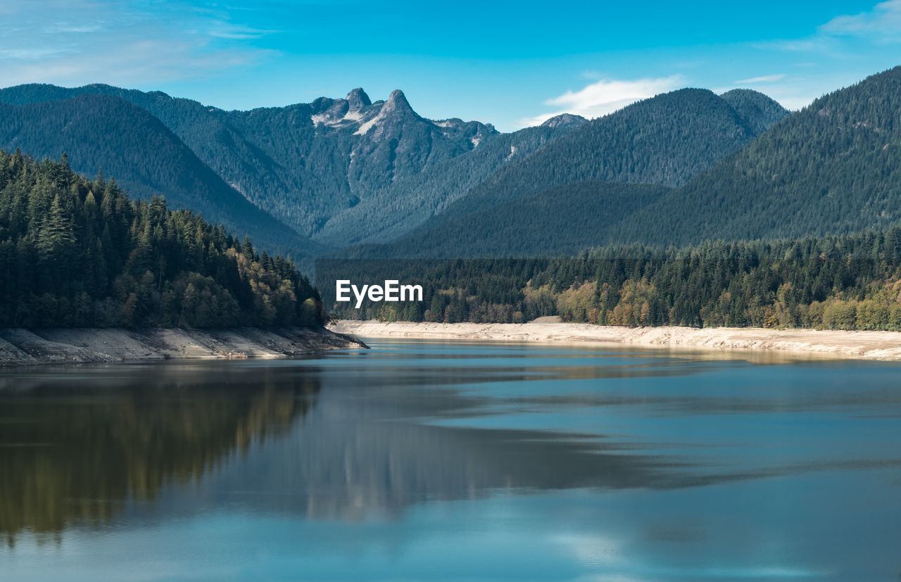 Scenic shot of calm river against mountain range