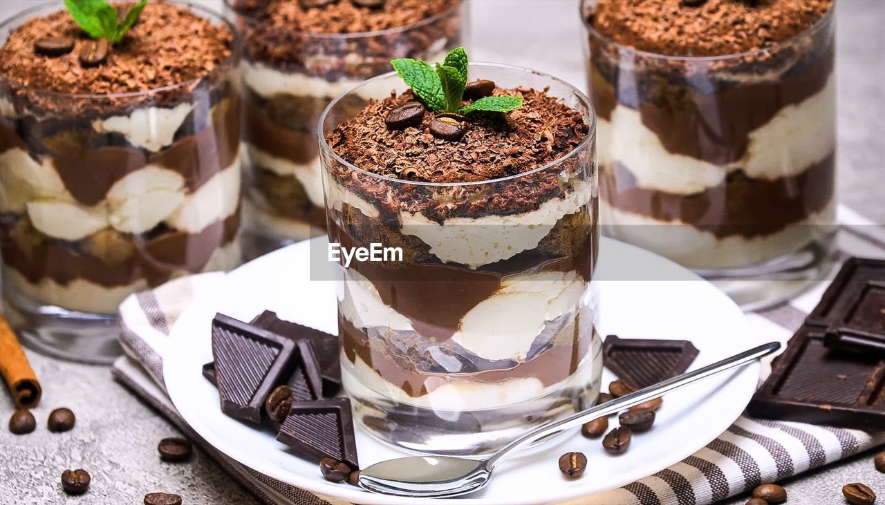 Dessert with chocolate, coffee and whipped cream in a glass glass