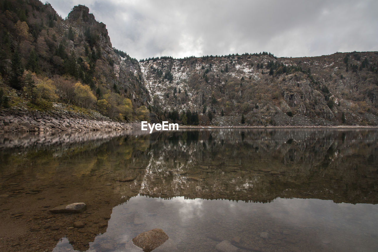 REFLECTION OF ROCKS IN LAKE WATER