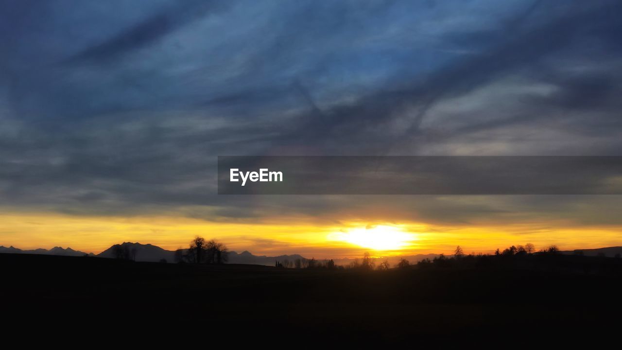 SCENIC VIEW OF DRAMATIC SKY OVER SILHOUETTE TREES