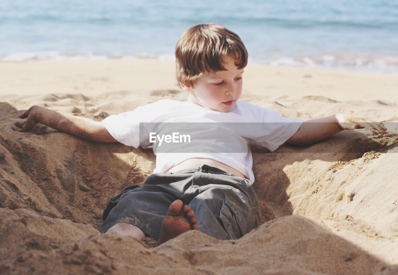 Boy playing on sand at beach