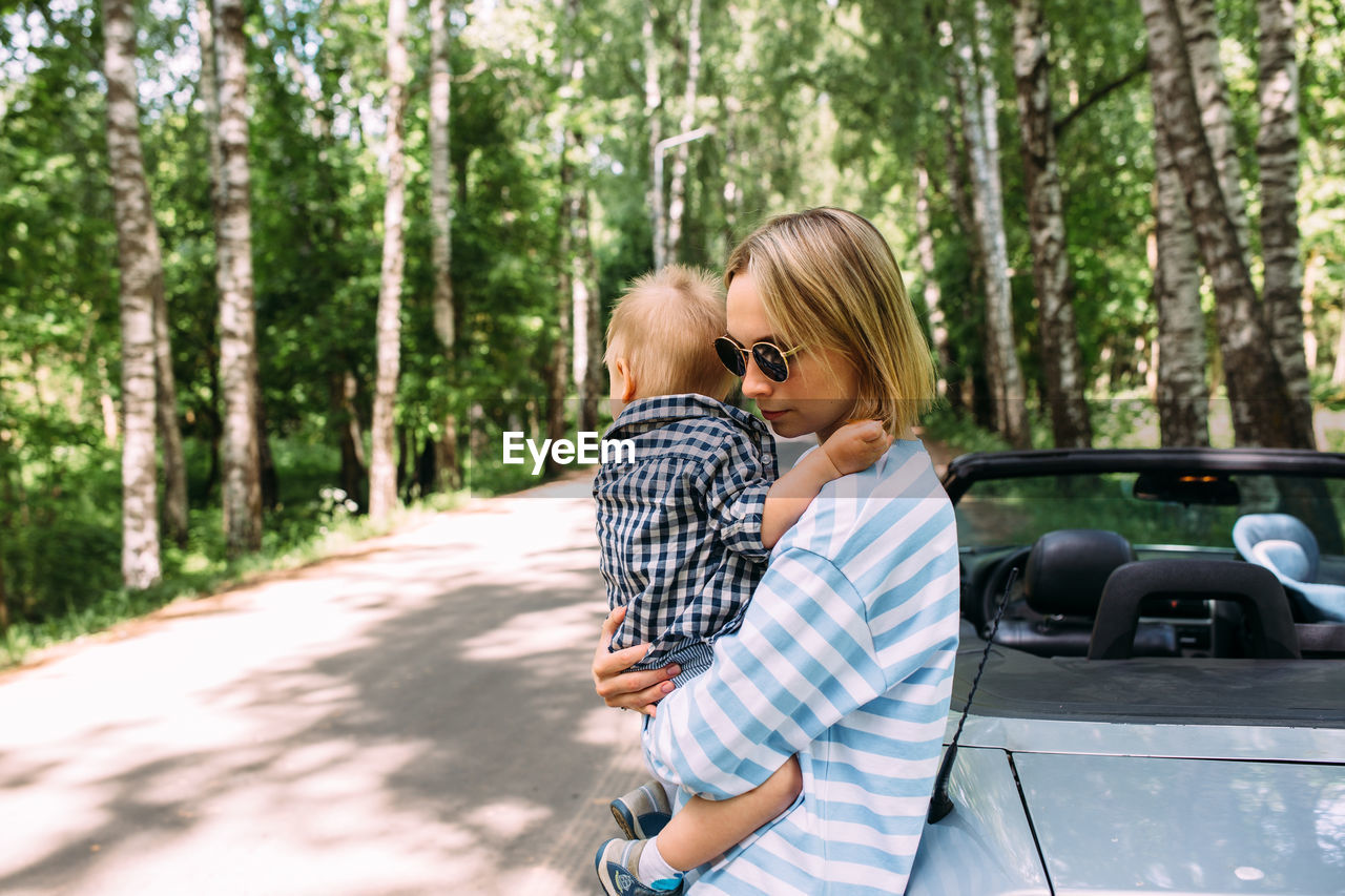 Mom and little son in a convertible car. summer family road trip to nature