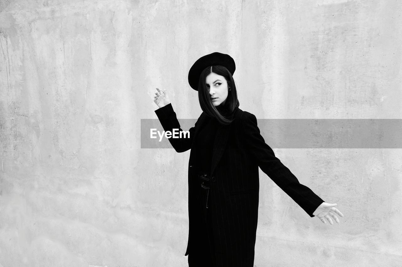Smiling woman standing against wall