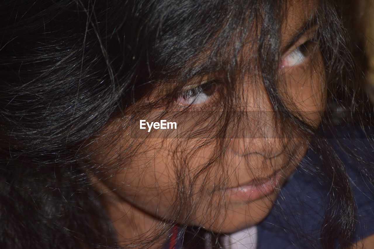 Close-up of sad girl with messy hair looking away at home