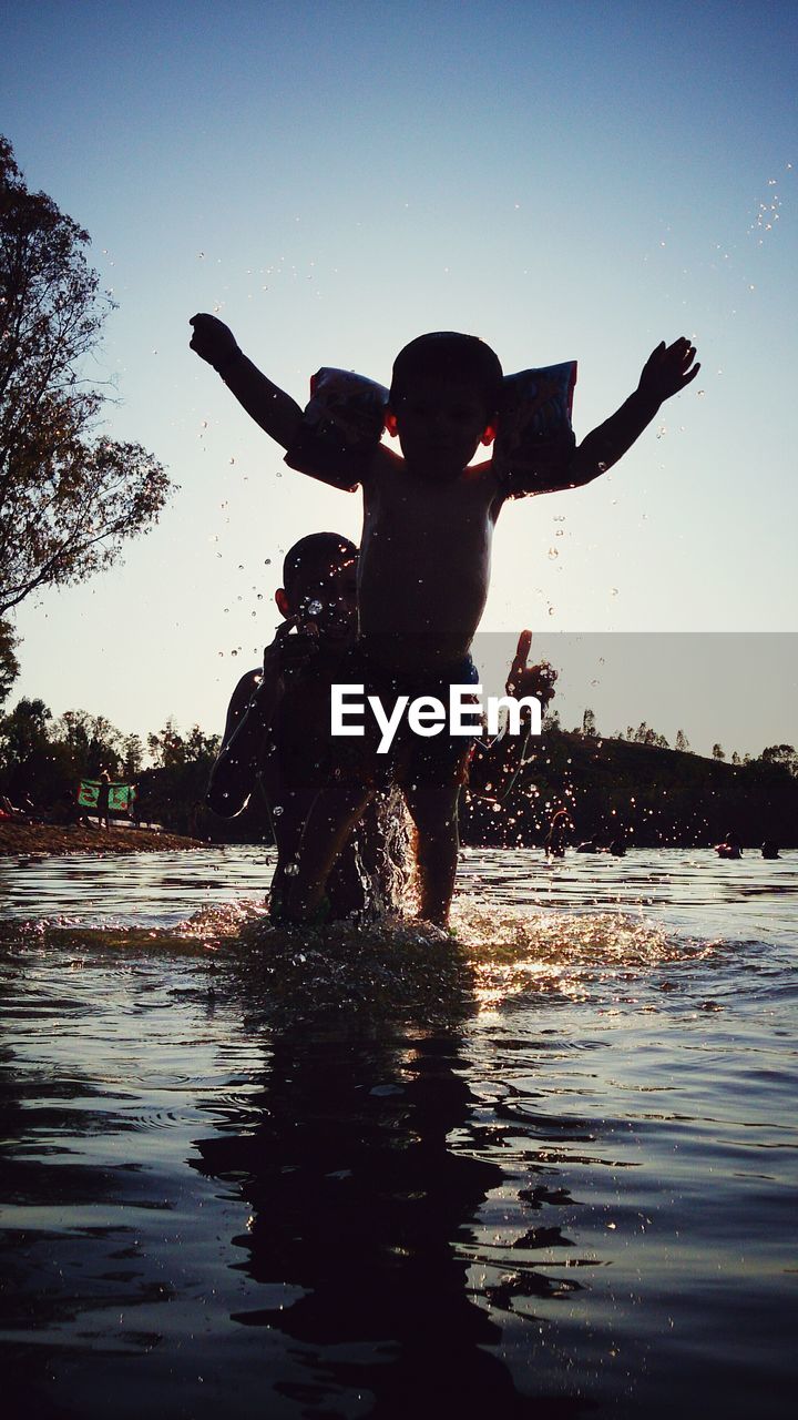 Father and son enjoying in river during summer