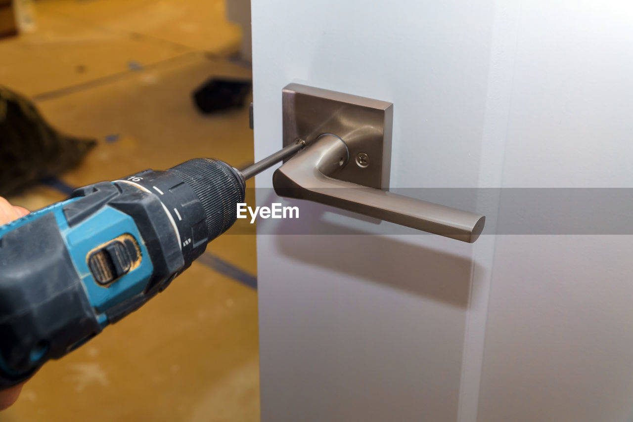 Close-up of drill fixing doorknob