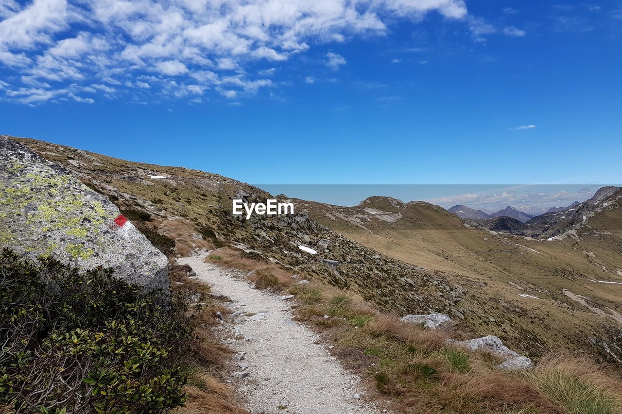 Scenic view of mountain trail against blue sky