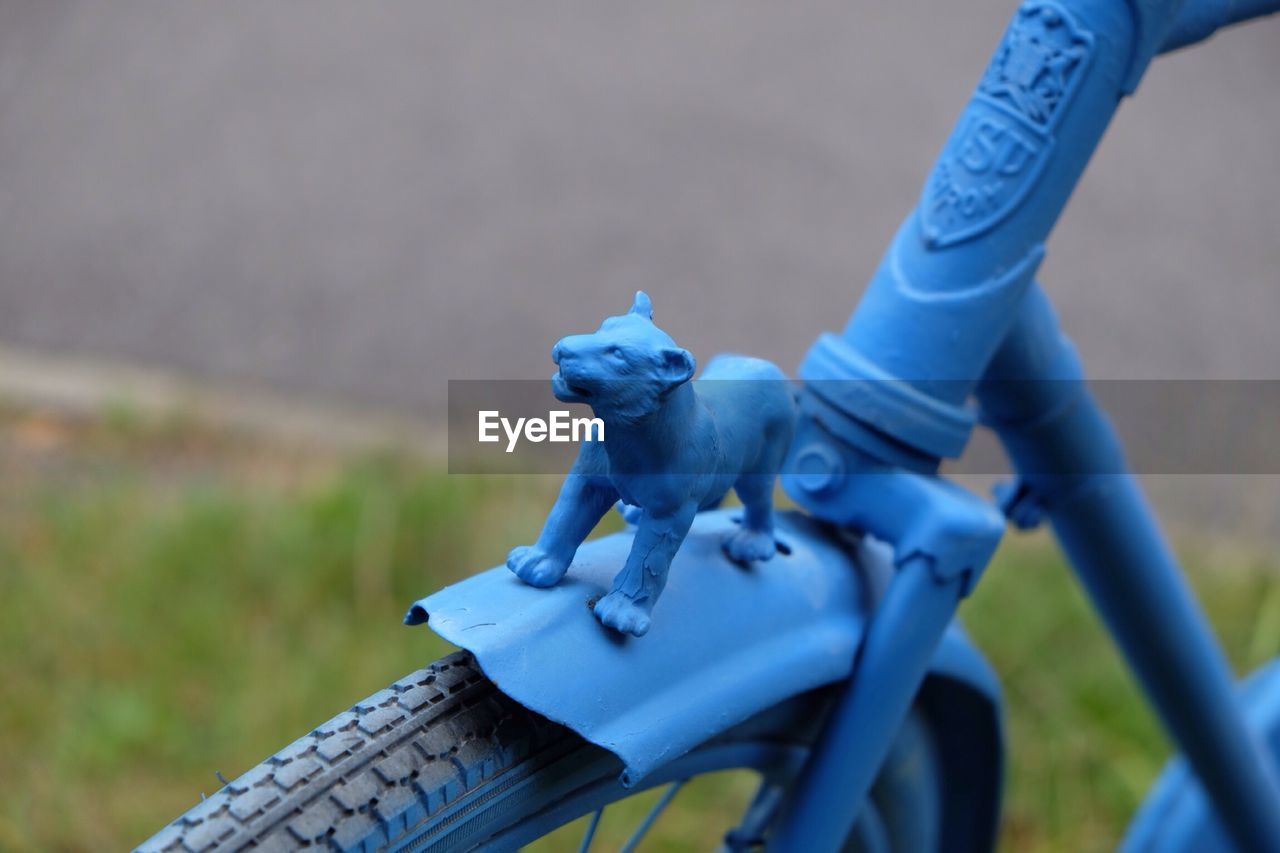 Animal figurine on blue bicycle