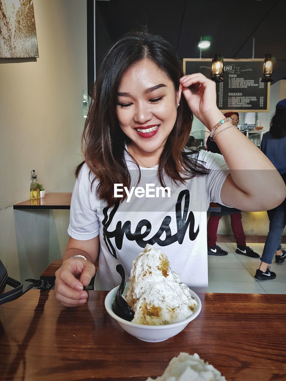 Smiling woman having dessert at cafe