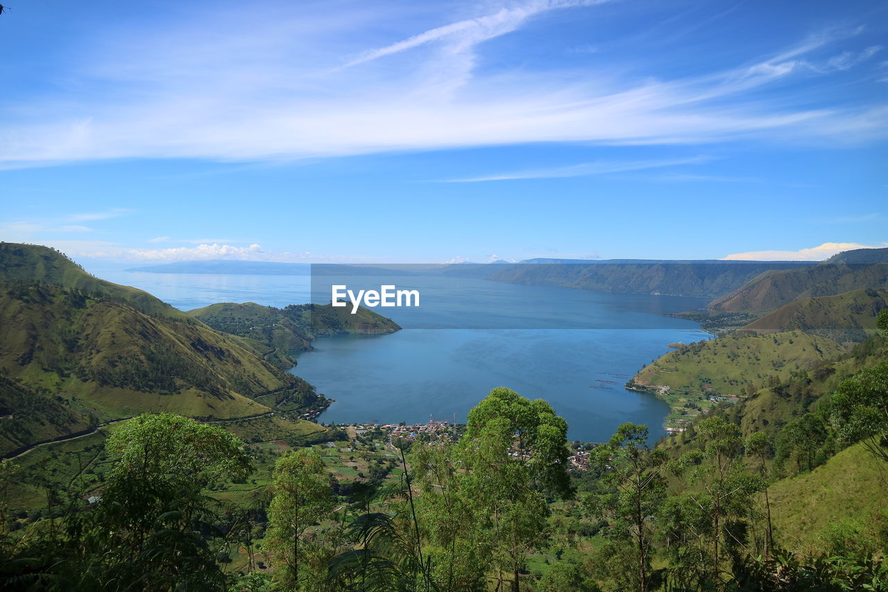 Scenic view of sea and mountains against sky